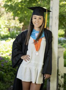 high school senior girl in cap and gown with an honors medal